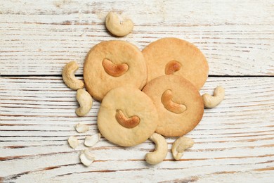 Photo of Tasty cashew cookies on rustic wooden table, flat lay