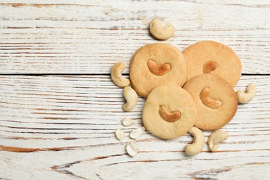 Photo of Tasty cashew cookies on rustic wooden table, flat lay. Space for text