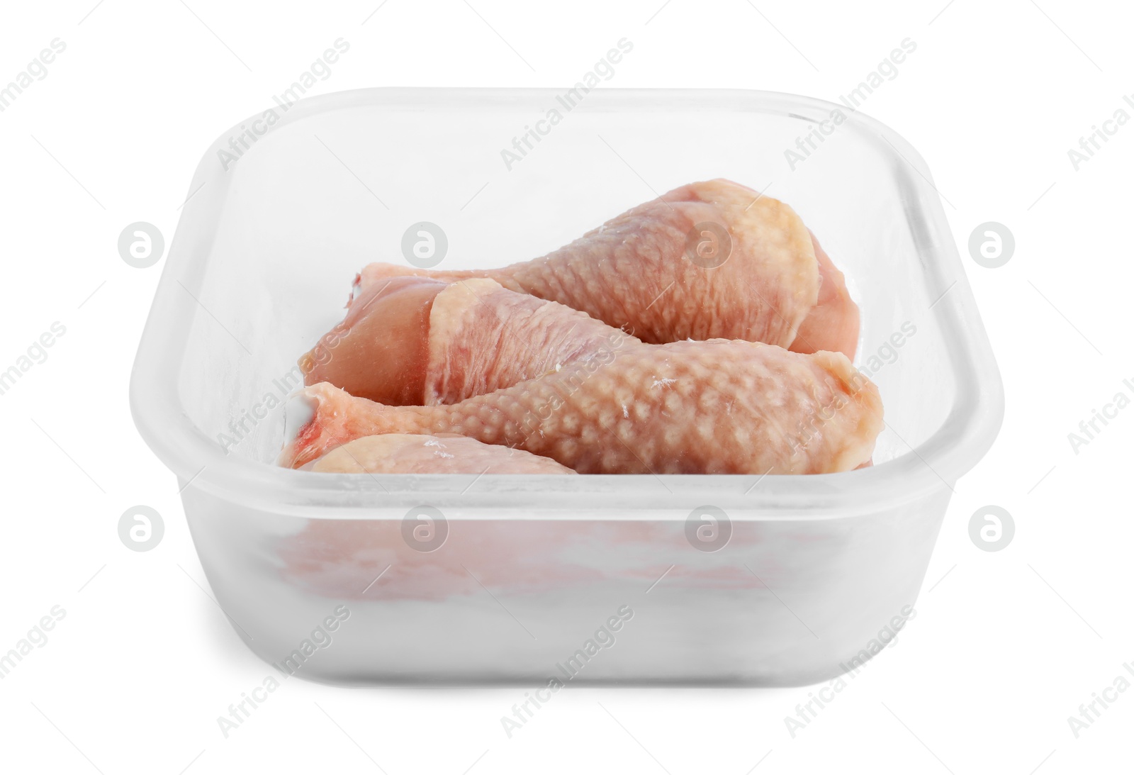 Photo of Frozen chicken drumsticks in container isolated on white