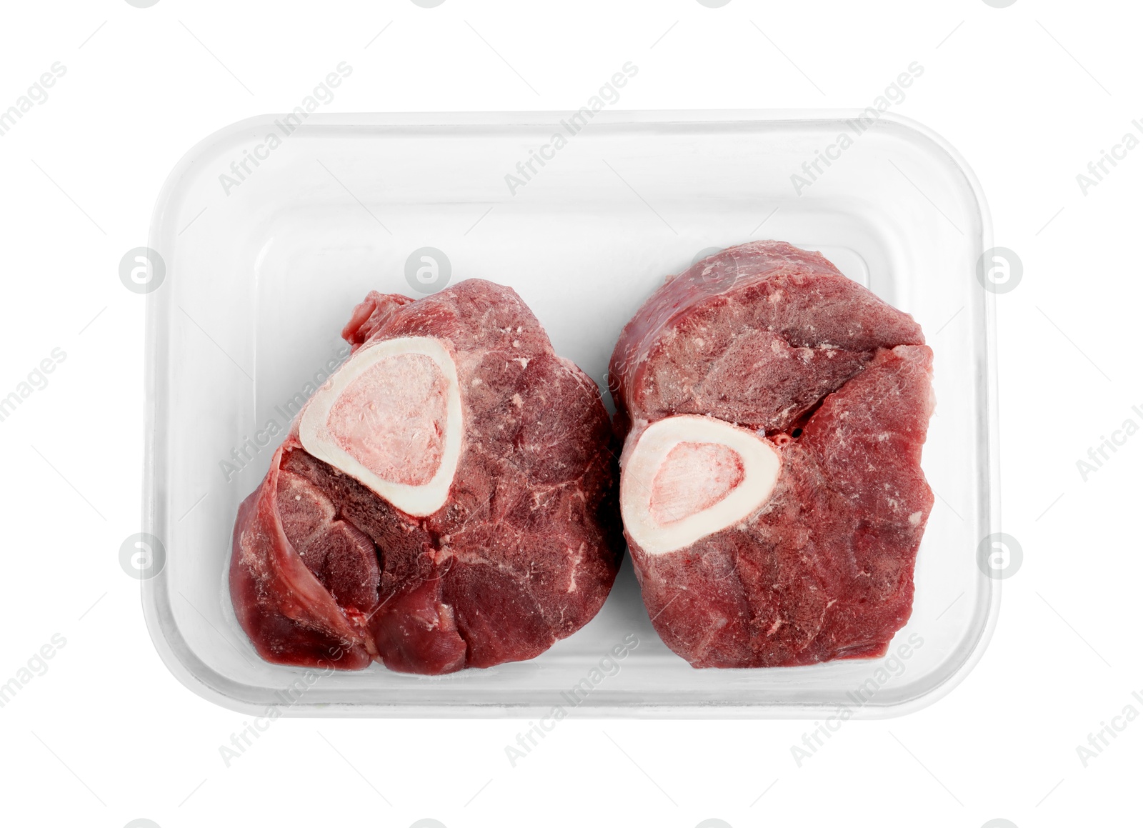 Photo of Frozen beef steaks in container isolated on white, top view