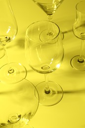 Photo of Empty glasses on yellow background, closeup. Color tone effect