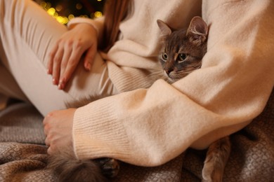 Photo of Woman with cute cat at home, closeup