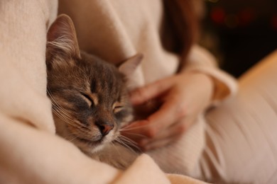 Photo of Woman with cute cat at home, closeup