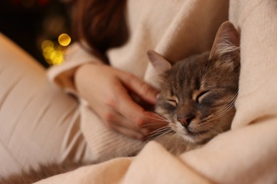 Photo of Woman with cute cat at home, closeup