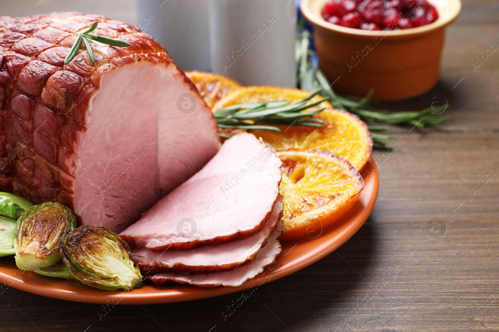 Photo of Christmas food. Tasty baked ham served on wooden table, closeup