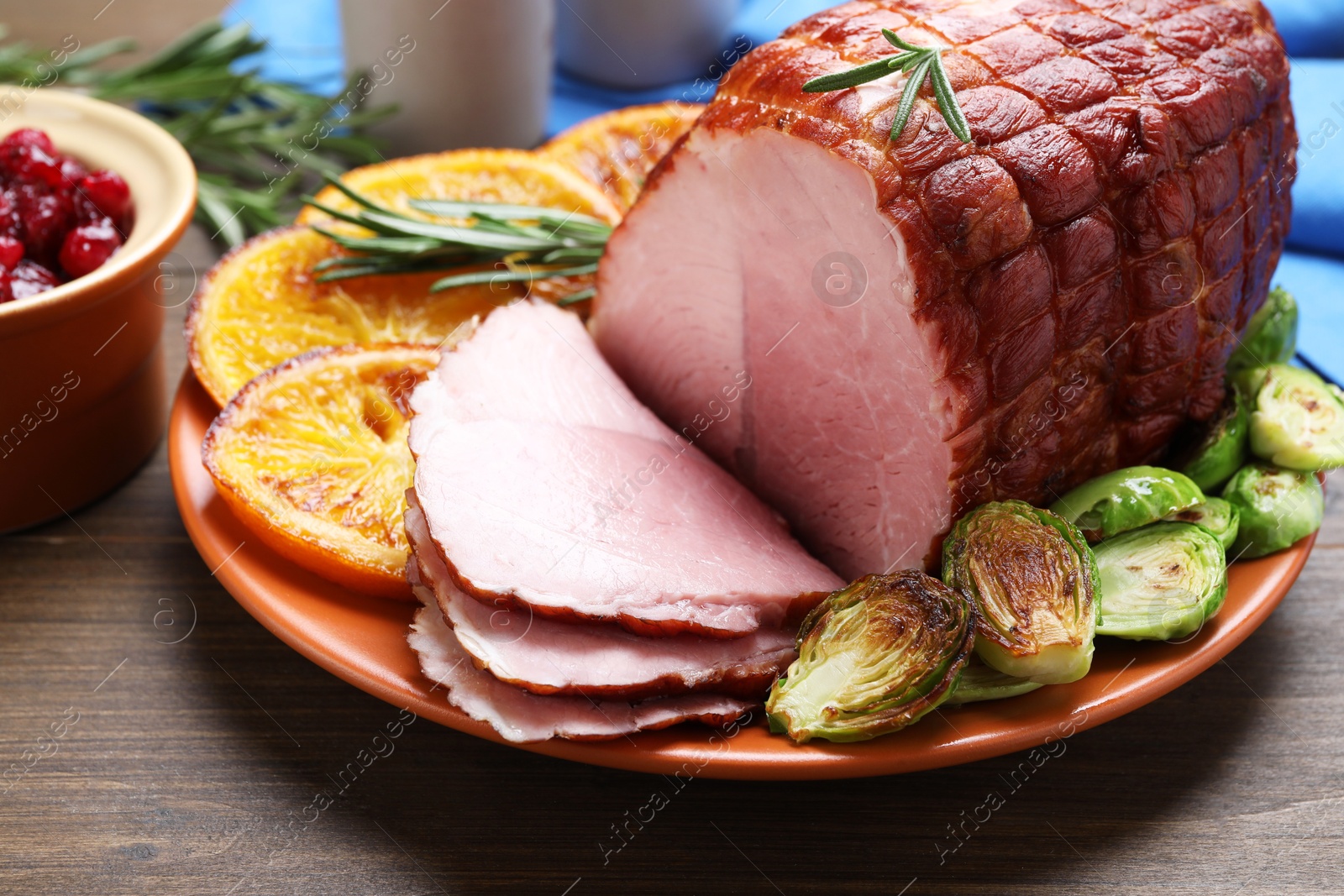 Photo of Christmas food. Tasty baked ham served on wooden table, closeup