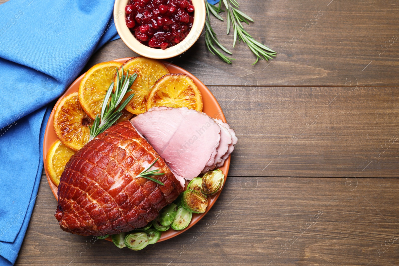 Photo of Christmas food. Tasty baked ham served on wooden table, flat lay and space for text