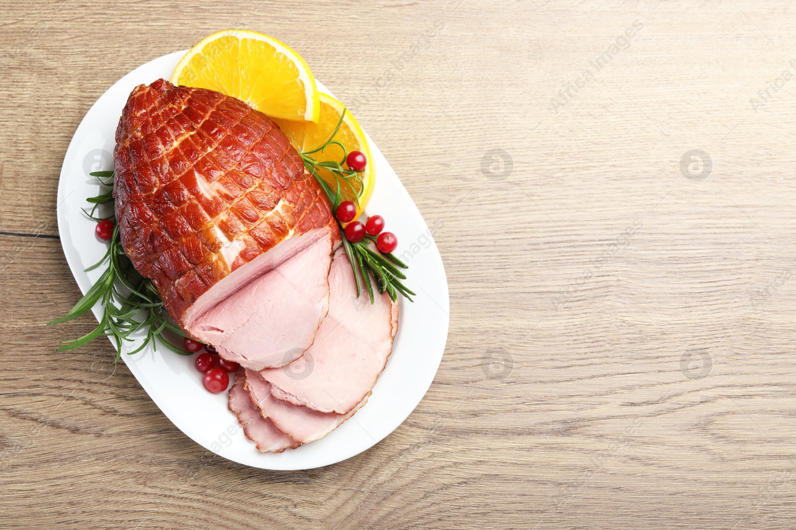 Photo of Christmas food. Tasty baked ham served on wooden table, top view and space for text