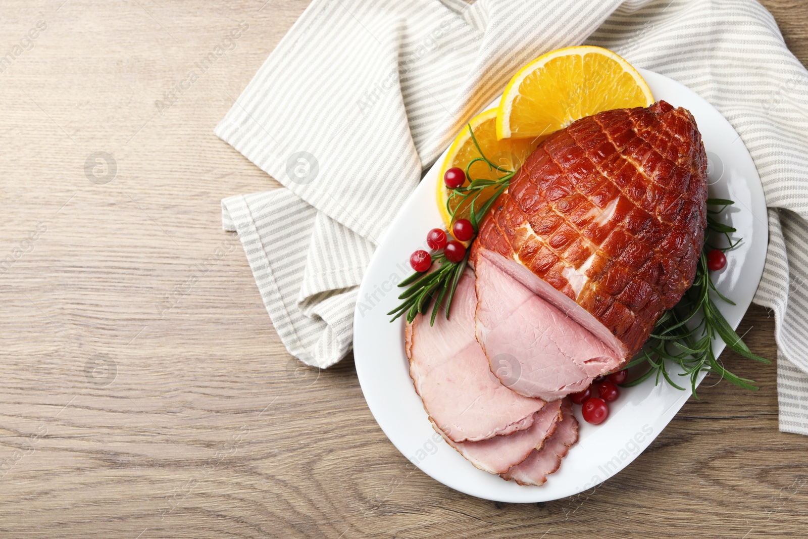 Photo of Christmas food. Tasty baked ham served on wooden table, top view and space for text