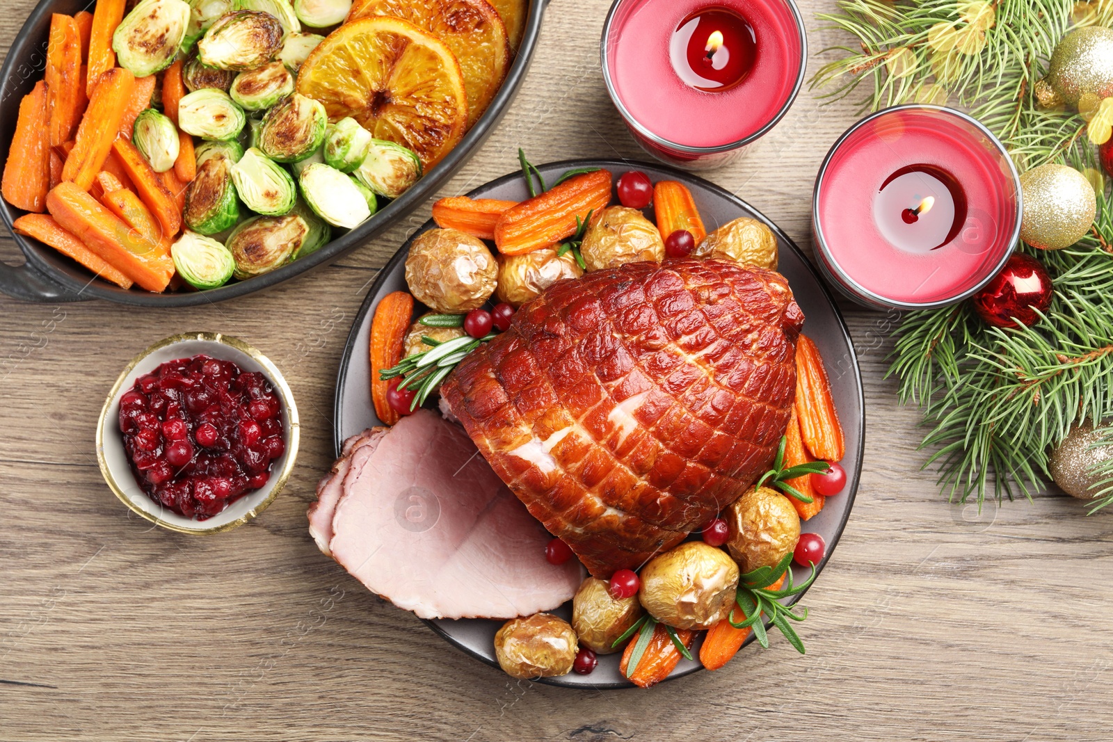 Photo of Christmas food. Tasty baked ham served on wooden table, flat lay