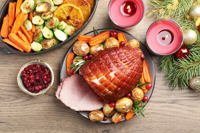 Photo of Christmas food. Tasty baked ham served on wooden table, flat lay