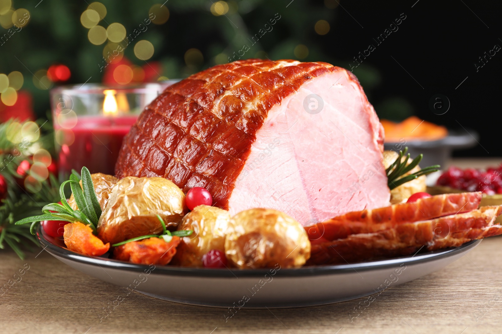 Photo of Christmas food. Tasty baked ham served on wooden table, closeup