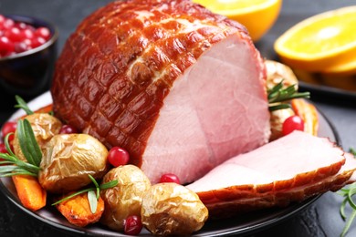 Photo of Christmas food. Tasty baked ham served on black table, closeup