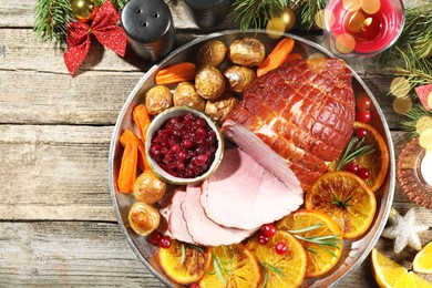 Photo of Christmas food. Tasty baked ham served on wooden table, flat lay