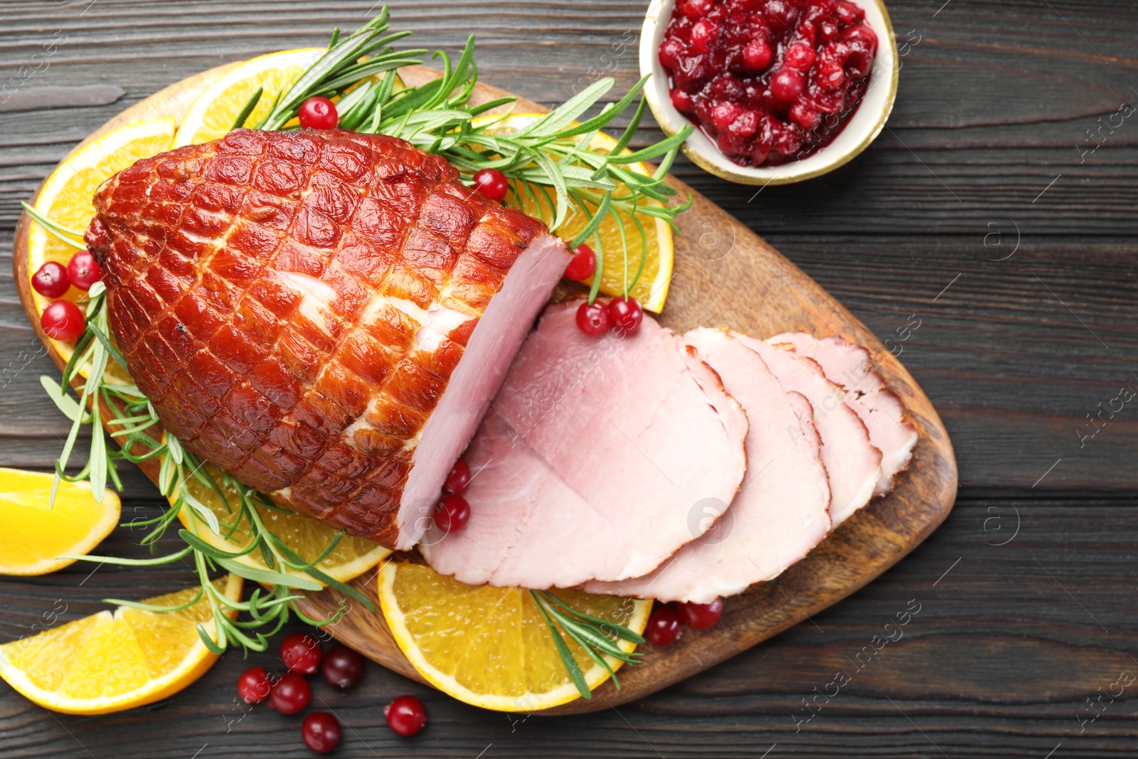 Photo of Christmas food. Tasty baked ham served on wooden table, flat lay