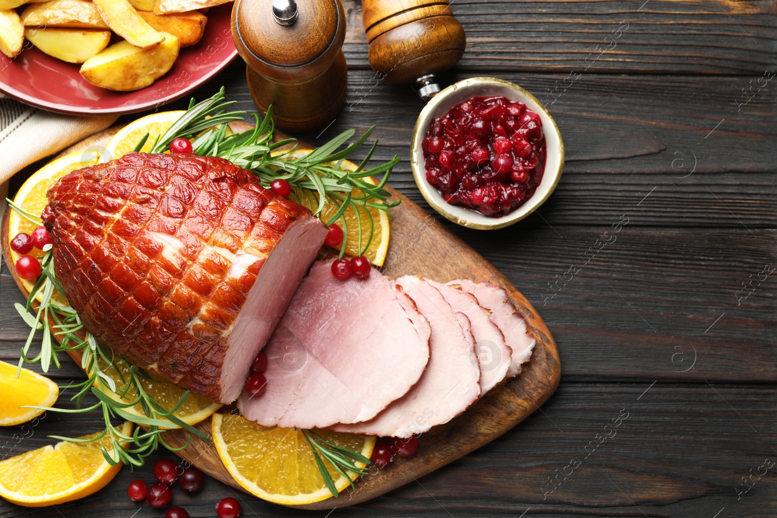 Photo of Christmas food. Tasty baked ham served on wooden table, flat lay