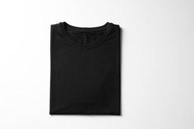 Photo of Blank black t-shirt on white background, top view. Mockup for design