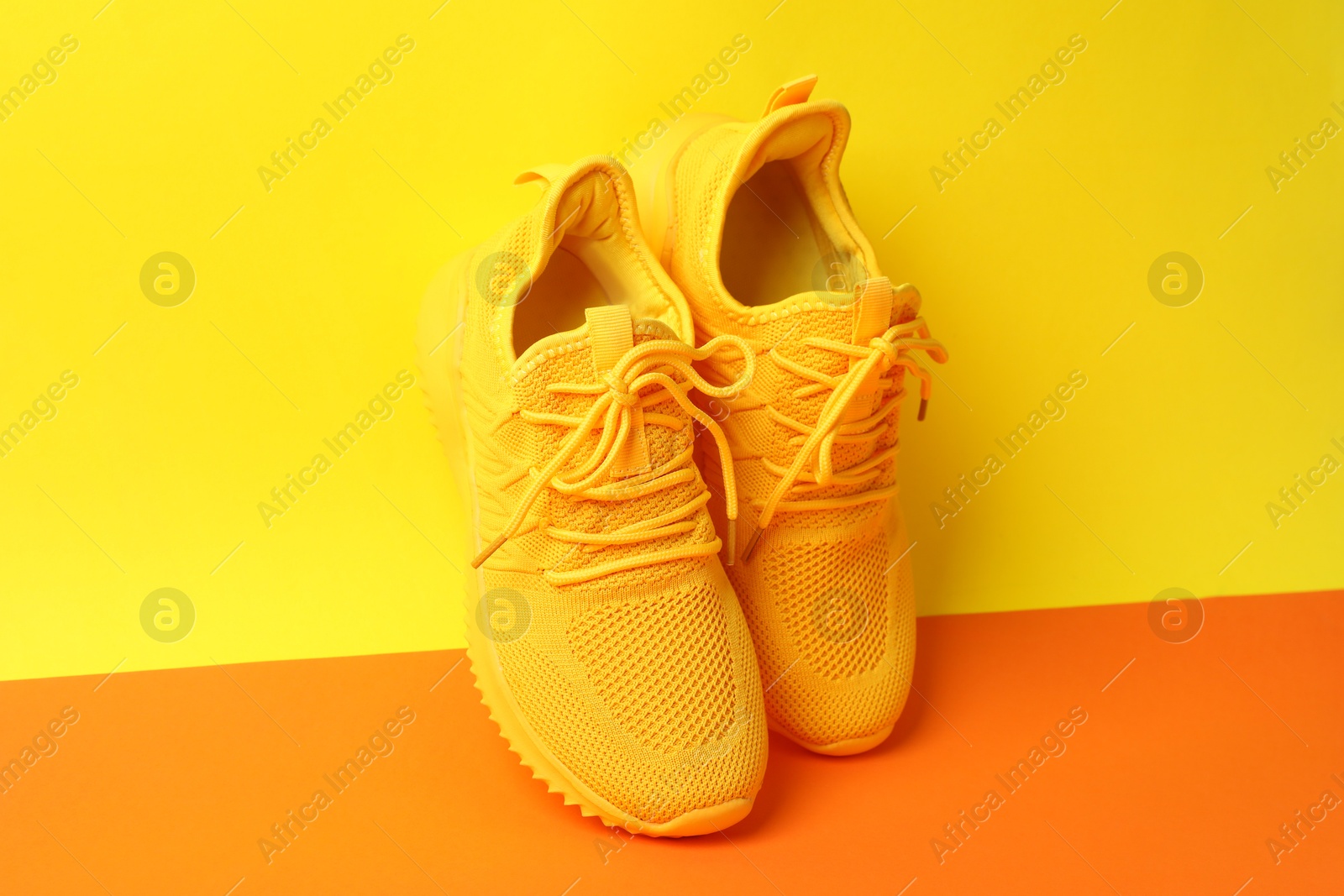 Photo of Pair of stylish sneakers on color background