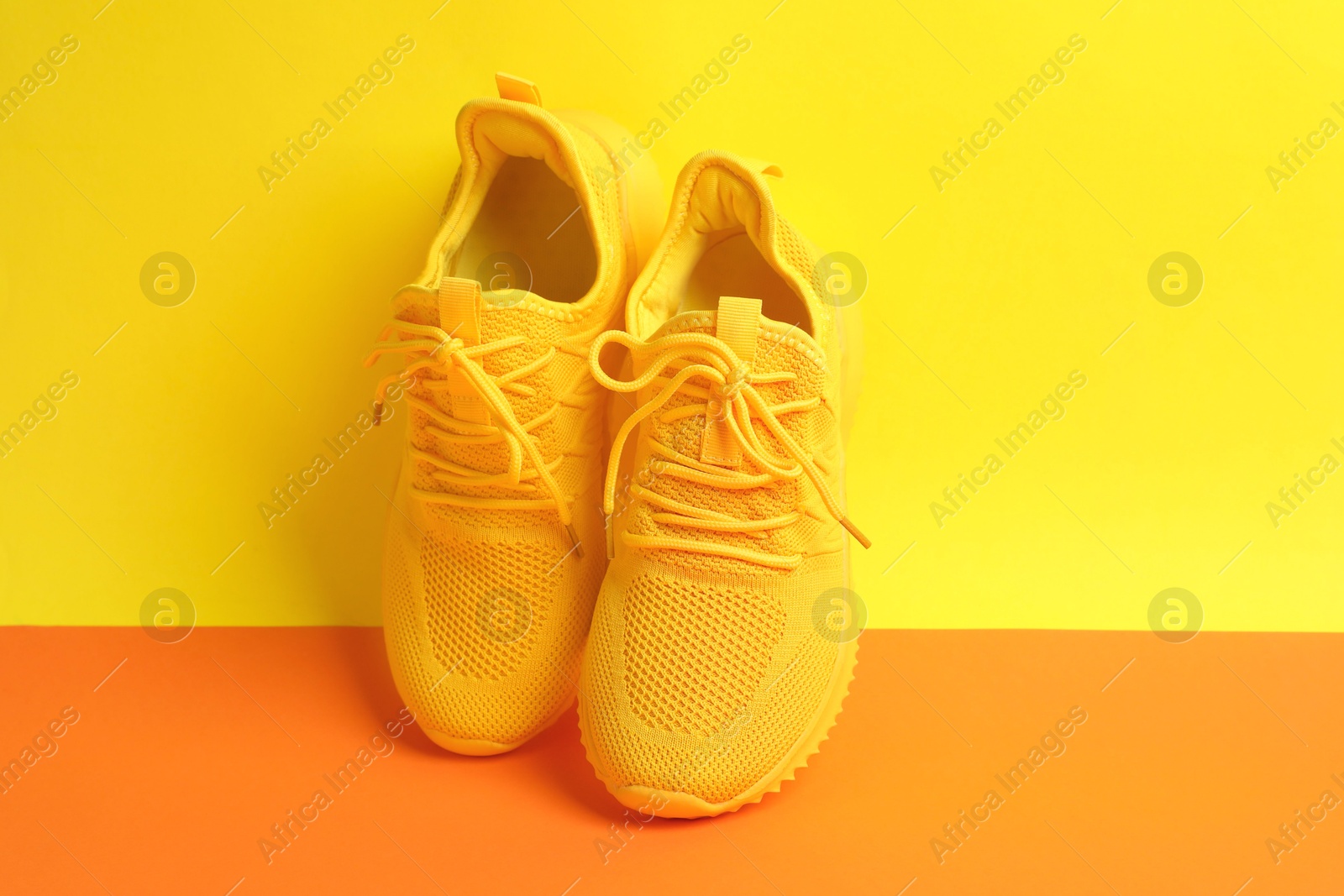 Photo of Pair of stylish sneakers on color background