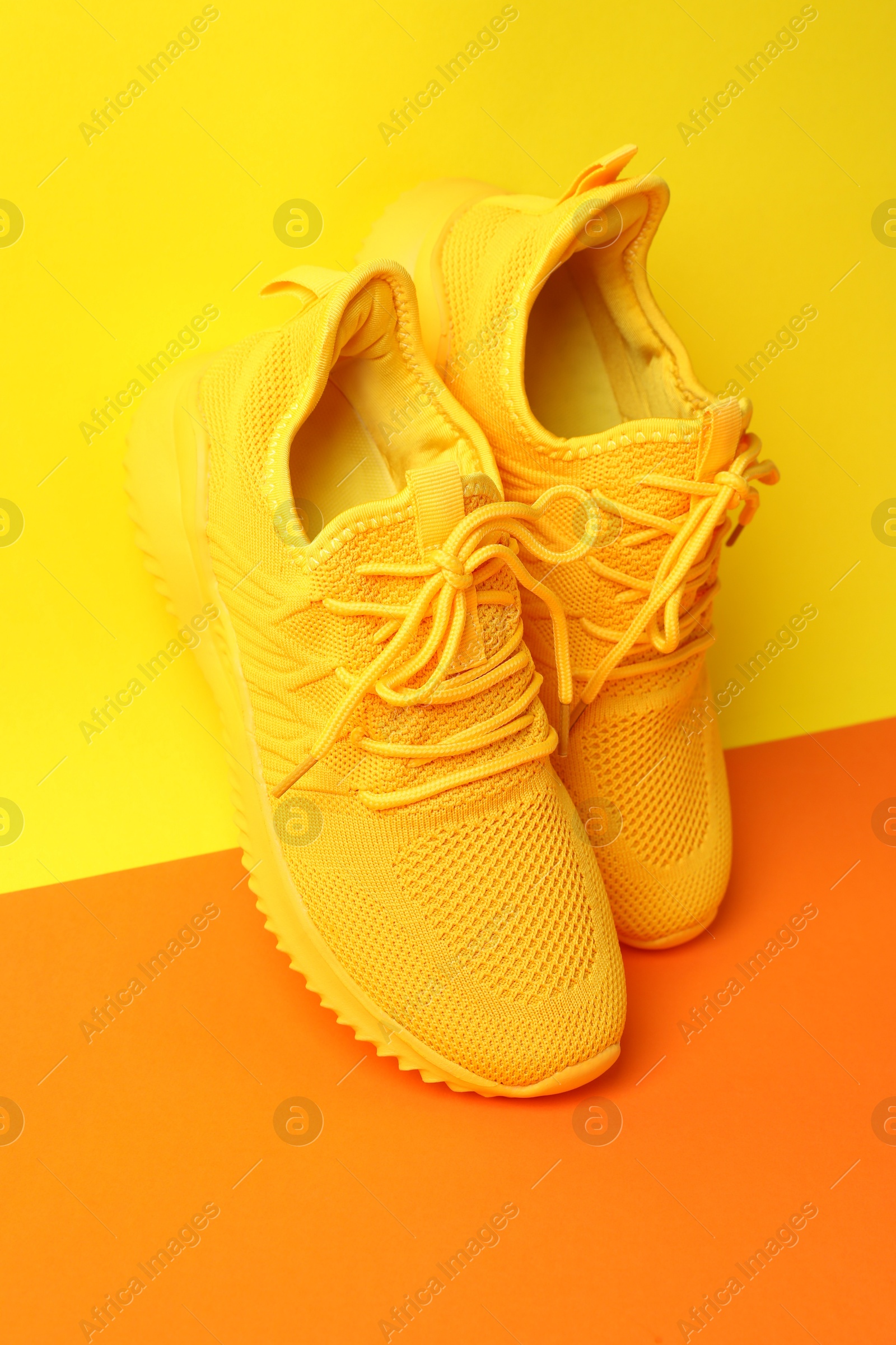 Photo of Pair of stylish sneakers on color background