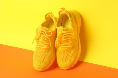 Photo of Pair of stylish sneakers on color background