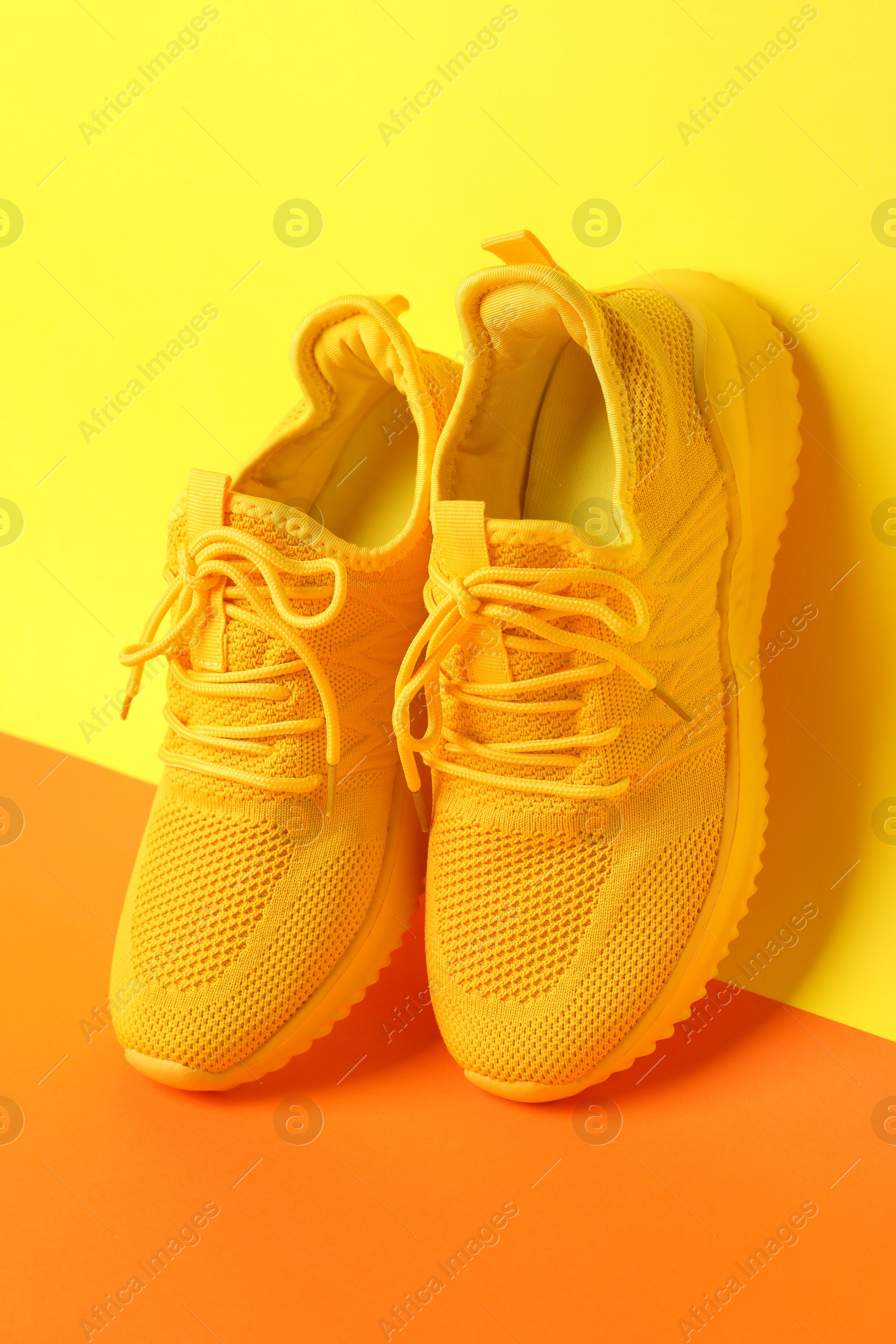 Photo of Pair of stylish sneakers on color background