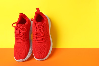 Photo of Pair of stylish sneakers on color background. Space for text