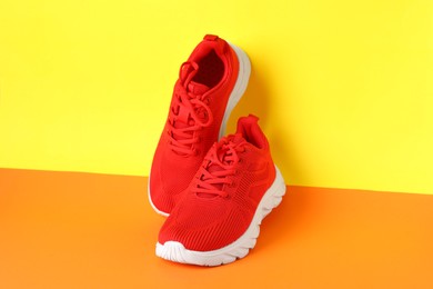 Photo of Pair of stylish sneakers on color background