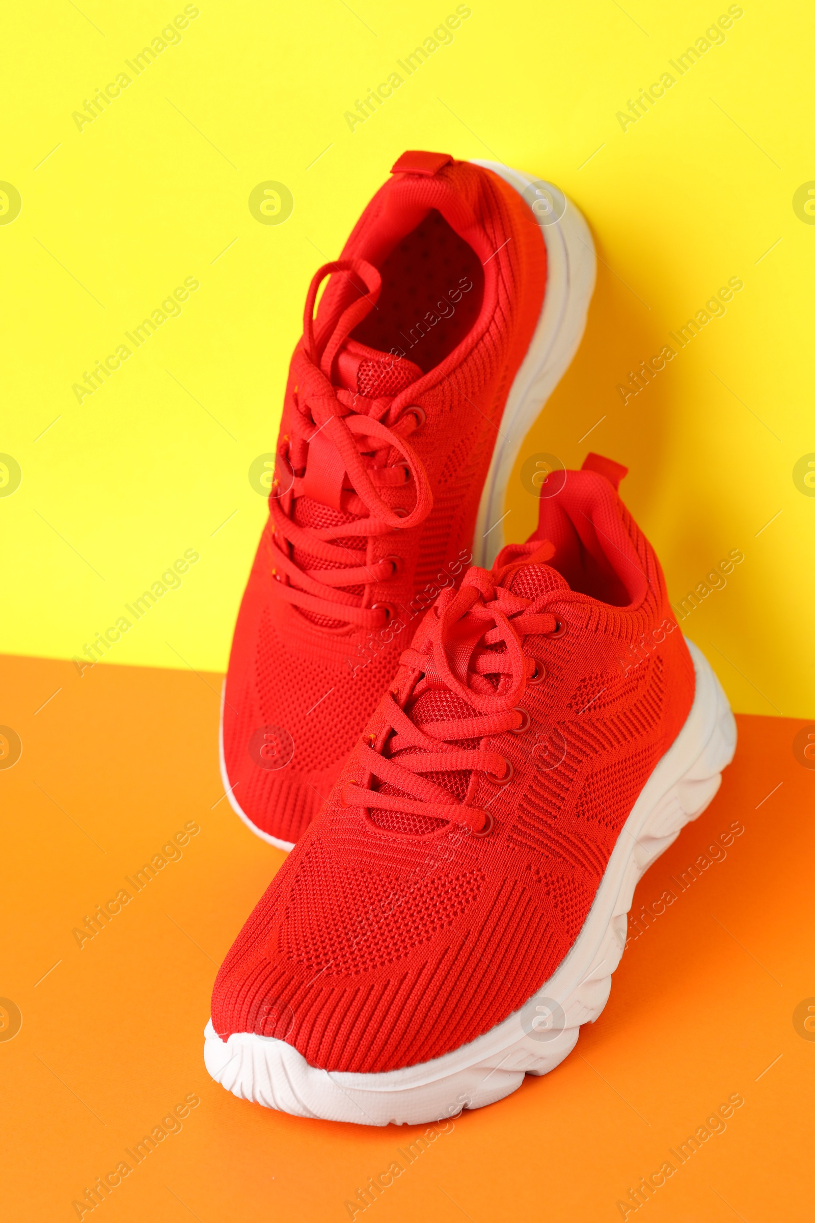 Photo of Pair of stylish sneakers on color background