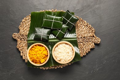 Photo of Cut banana leaves with rice on dark table, top view. Healthy eco serving