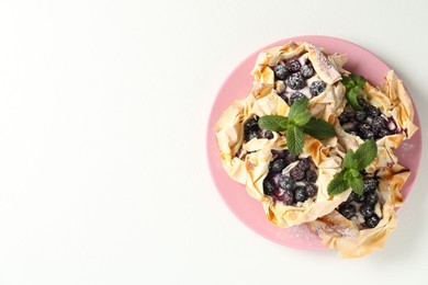 Photo of Tasty puff pastries with blueberries, powdered sugar and mint on white table, top view. Space for text