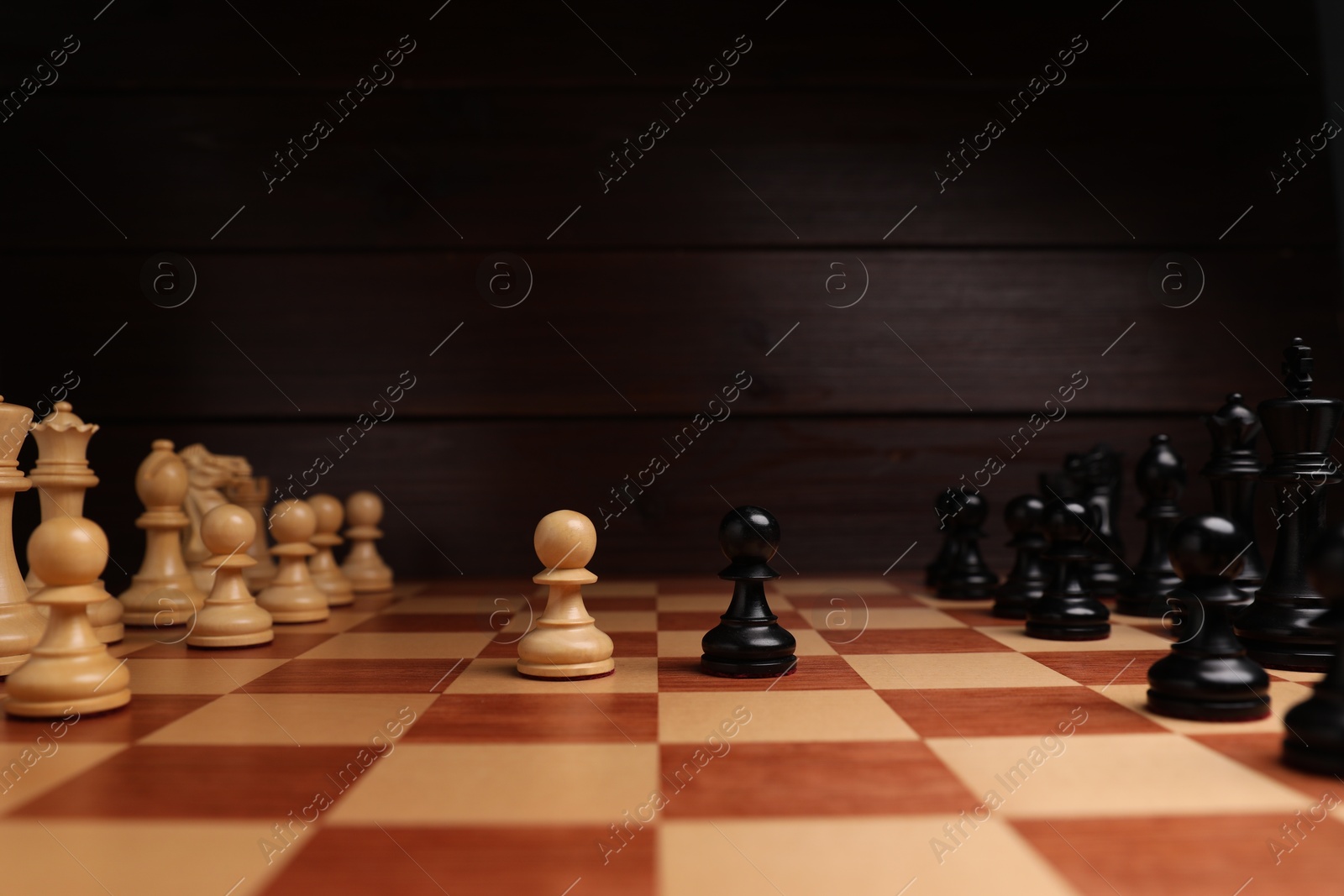 Photo of Black and white chess pawns in middle of chessboard. Competition concept