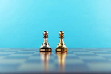 Photo of Golden and silver chess pawns in middle of chessboard. Competition concept