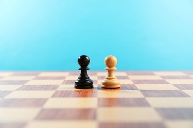 Photo of Black and white chess pawns in middle of chessboard. Competition concept