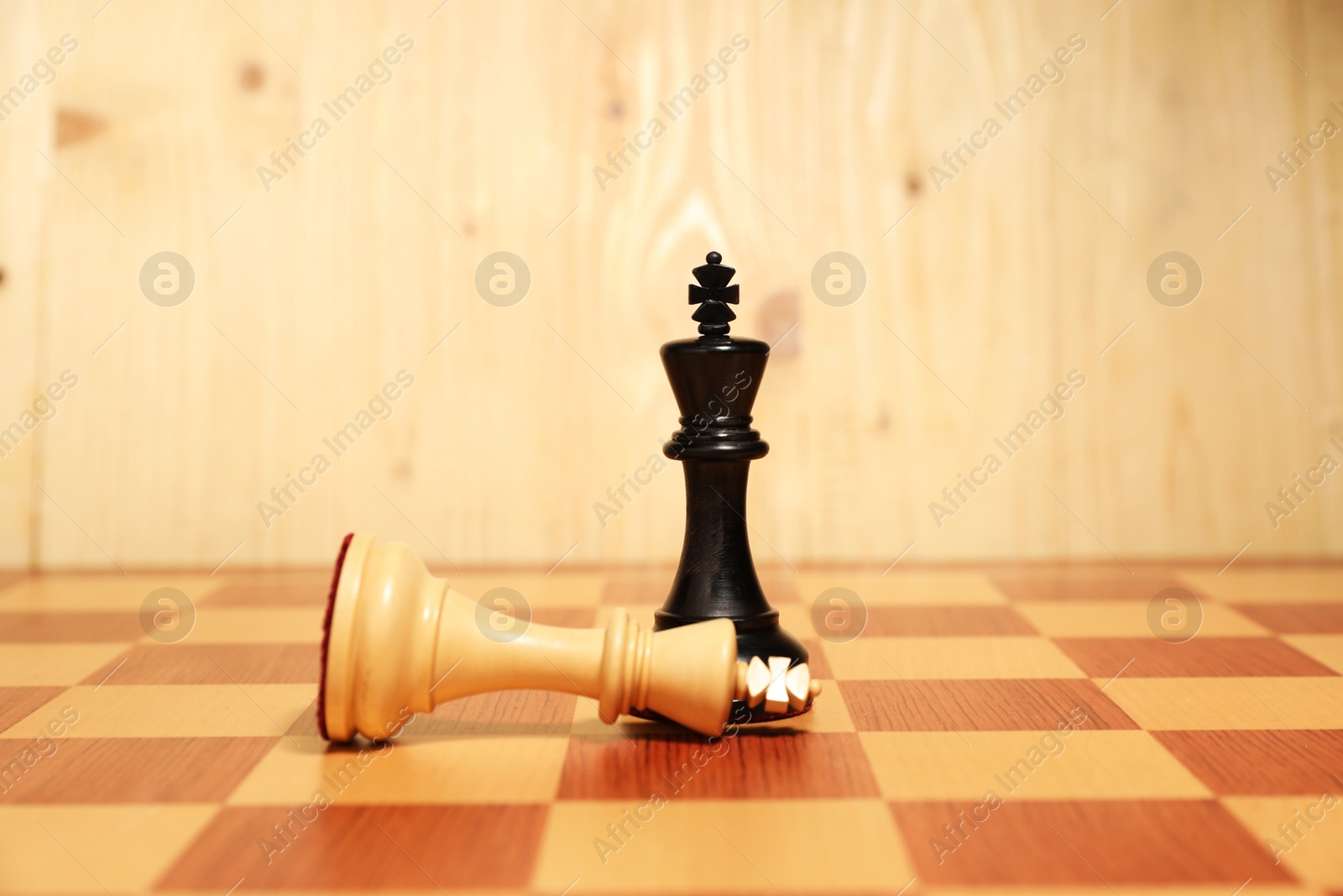 Photo of Black chess king near fallen white one in middle of chessboard. Competition concept