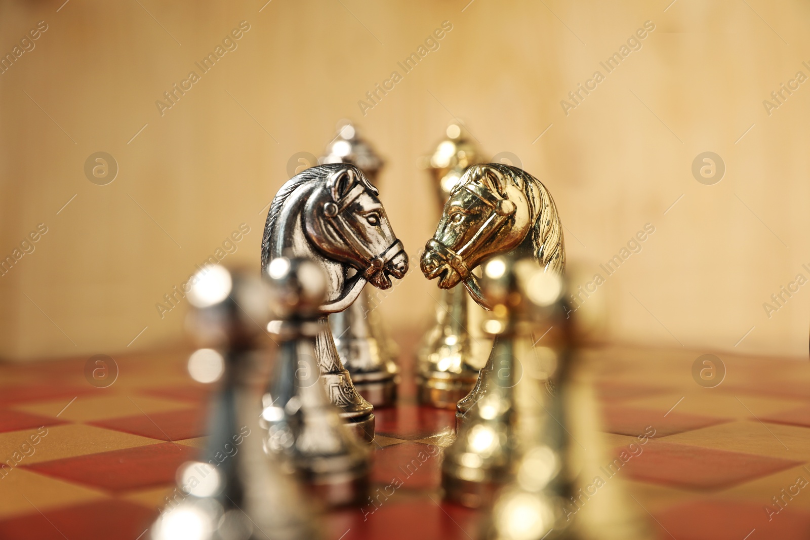 Photo of Golden and silver chess pieces on chessboard, closeup. Competition concept