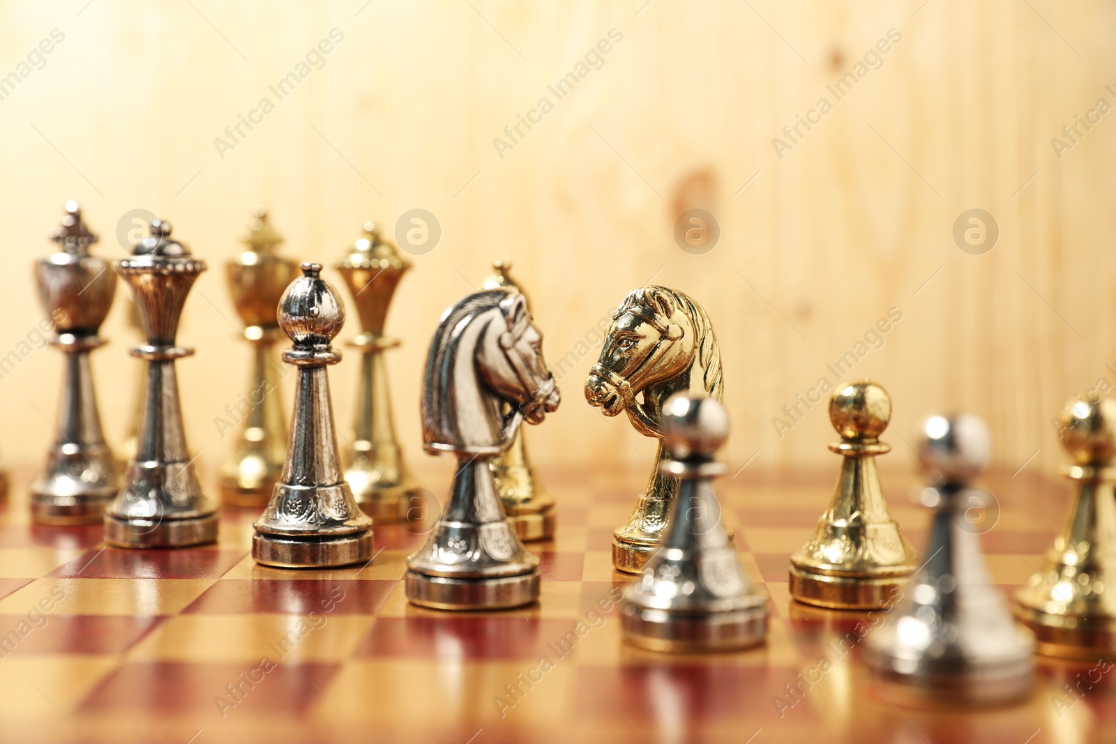 Photo of Golden and silver chess pieces on chessboard, closeup. Competition concept