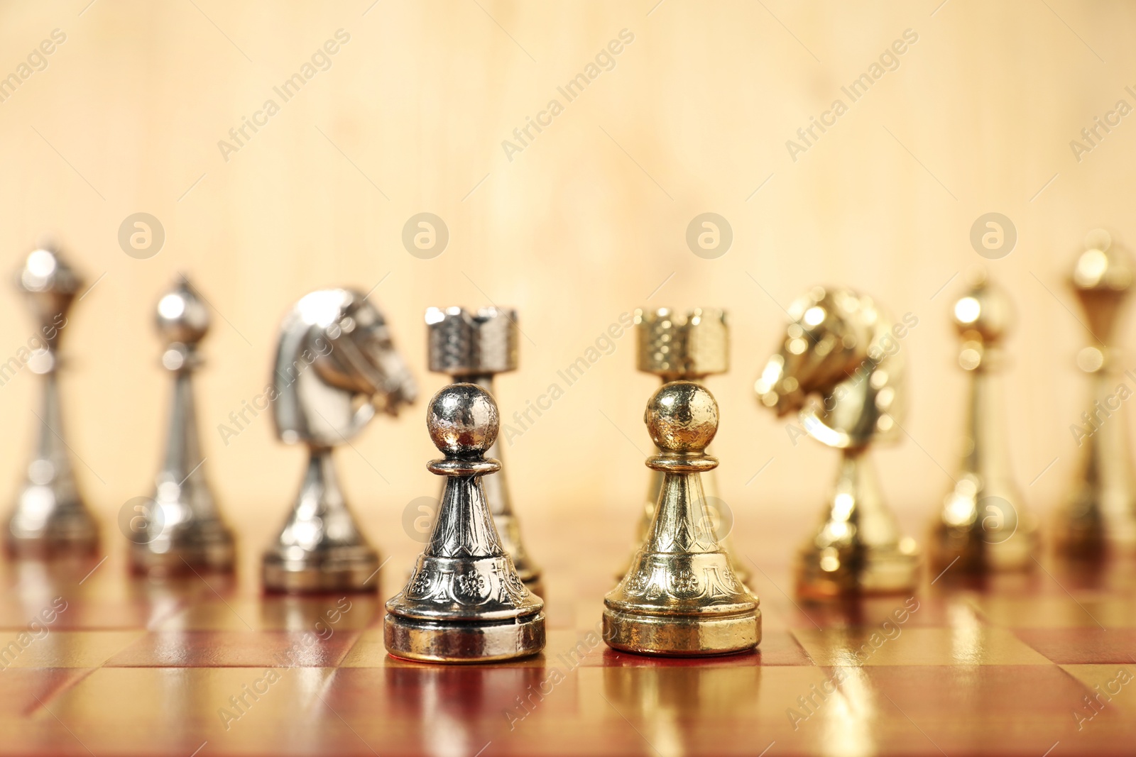 Photo of Golden and silver chess pieces on chessboard, closeup. Competition concept