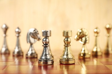 Photo of Golden and silver chess pieces on chessboard, closeup. Competition concept