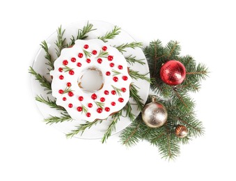 Photo of Beautifully decorated Christmas cake, fir branches and baubles on white background, top view