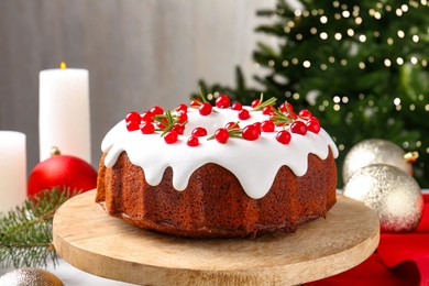 Photo of Traditional Christmas cake decorated with red currants and rosemary on table, closeup