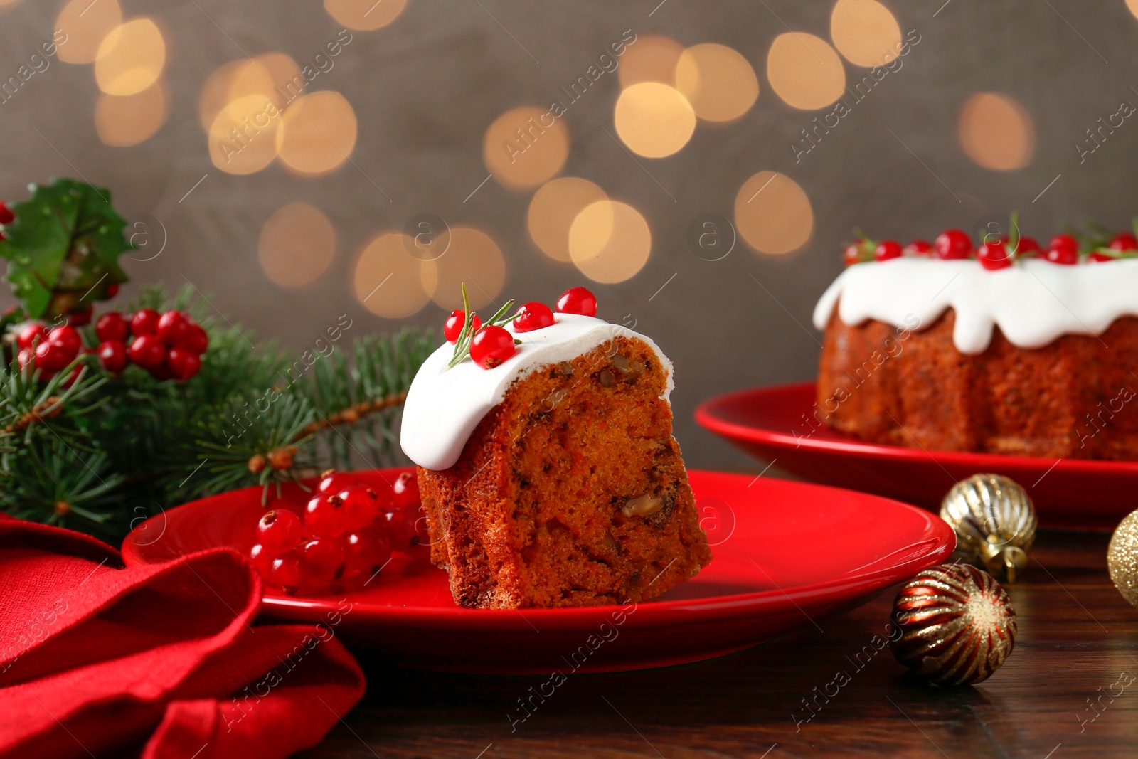 Photo of Piece of traditional classic Christmas cake and decor on wooden table against blurred lights