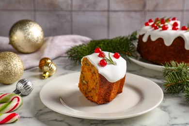 Photo of Piece of traditional classic Christmas cake and decor on white marble table