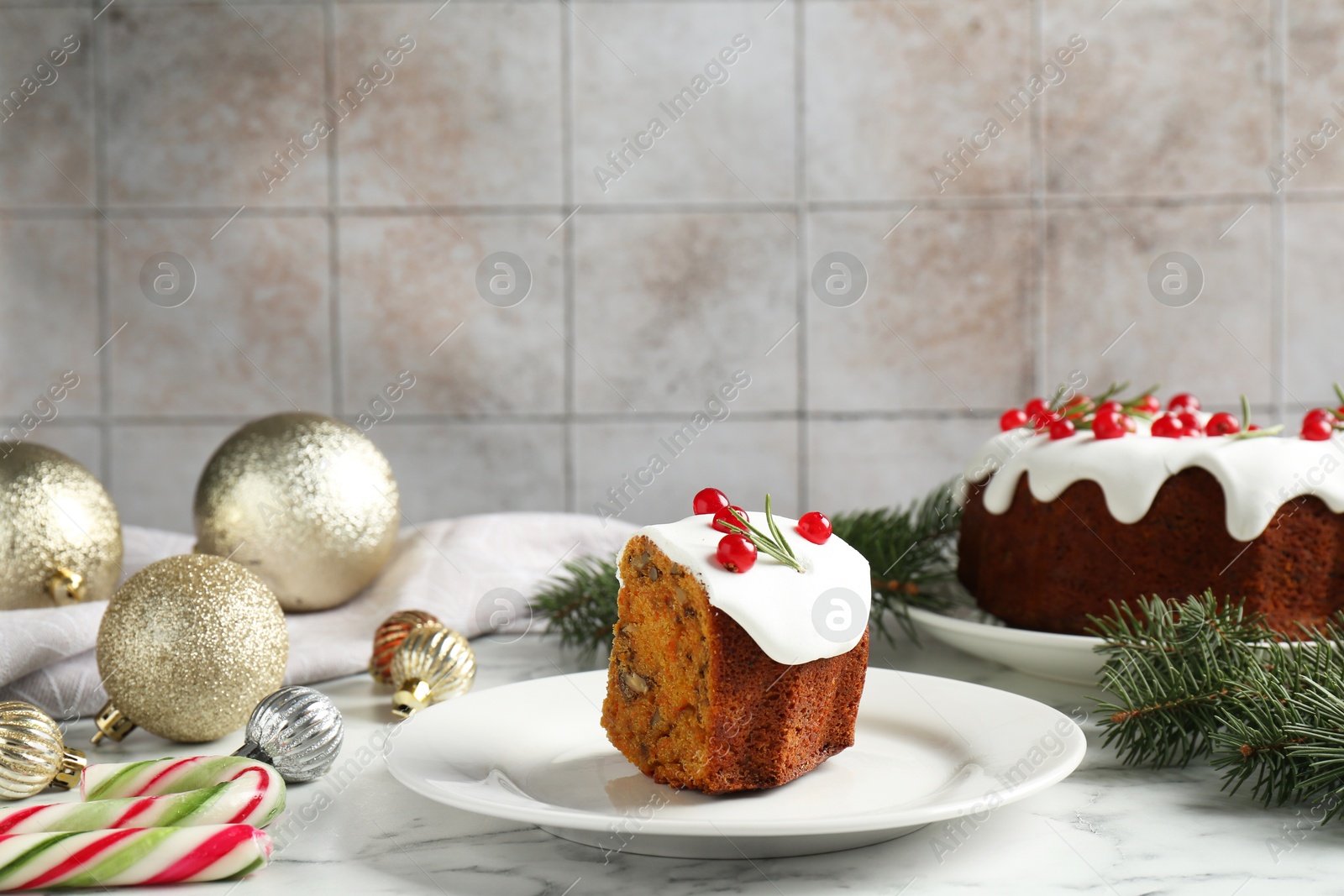 Photo of Piece of traditional classic Christmas cake and decor on white marble table