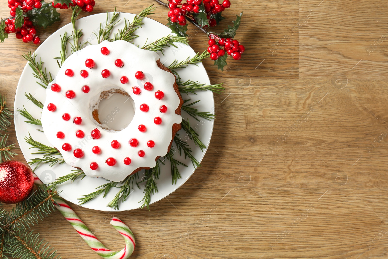 Photo of Traditional classic Christmas cake and decor on wooden table, flat lay. Space for text