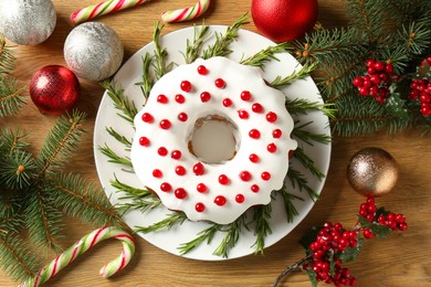 Photo of Traditional classic Christmas cake and decor on wooden table, flat lay