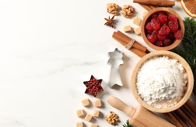 Photo of Different aromatic spices and fir tree branches on white table, flat lay with space for text. Christmas season