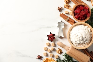 Photo of Different aromatic spices and fir tree branches on white table, flat lay with space for text. Christmas season