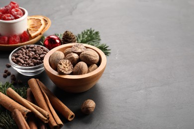 Photo of Different aromatic spices on black table, closeup with space for text. Christmas season