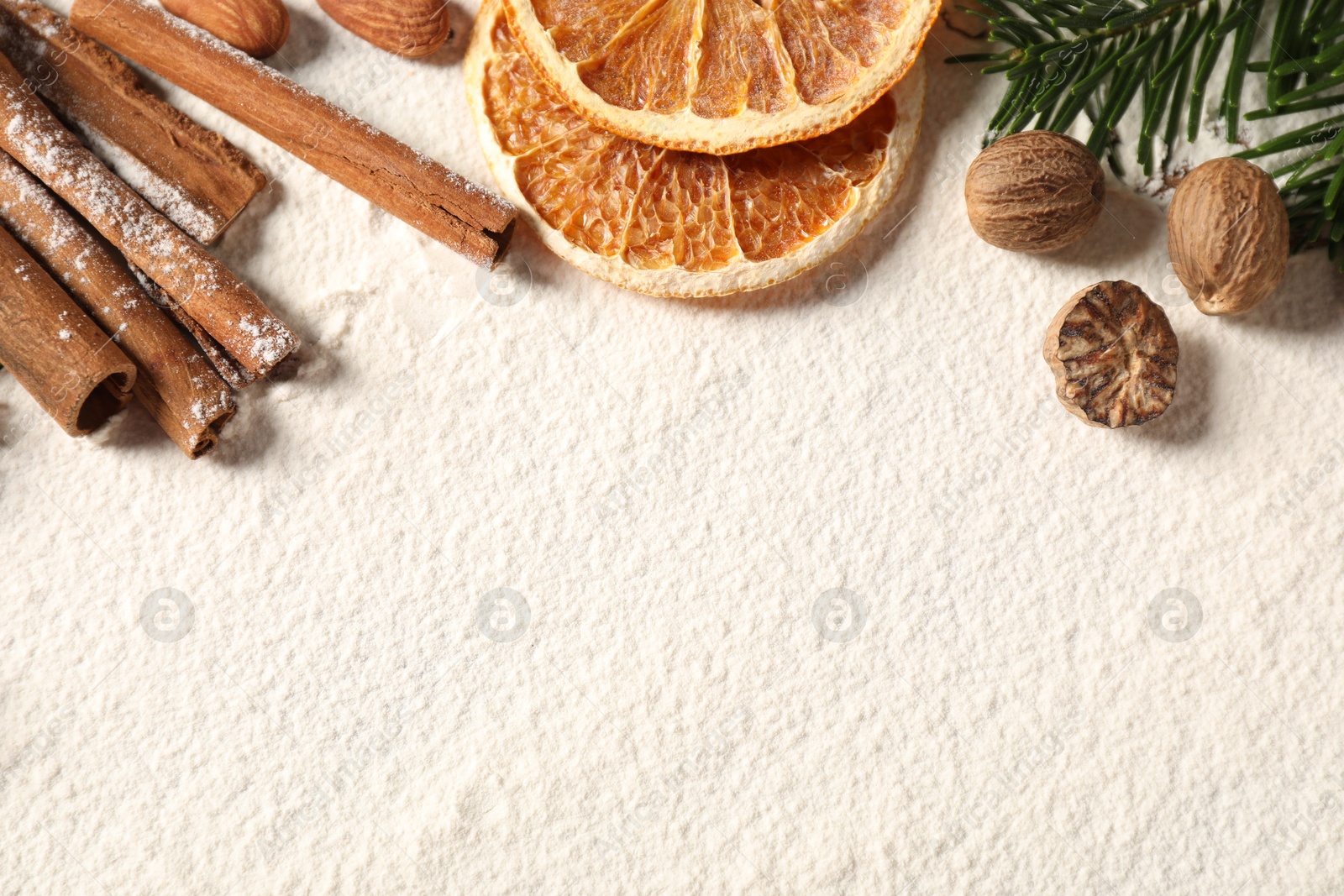 Photo of Different aromatic spices and fir tree branch on table, flat lay with space for text. Christmas season